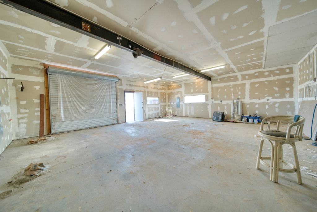 A large room with freshly taped and mudded drywall on the walls and ceiling (illustrative)